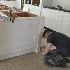 Craftsman installing a bespoke painted wood kitchen